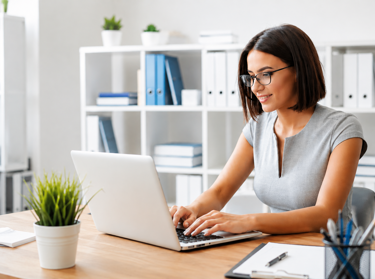 woman with grey shirt looking at laptop