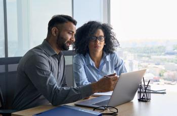 man and woman looking at the laptop