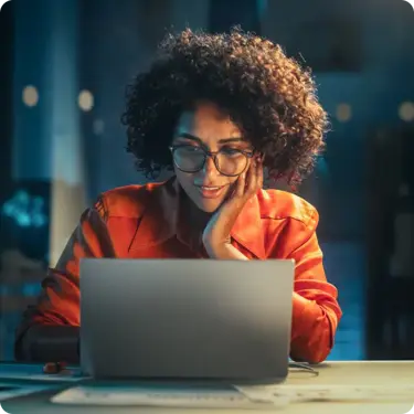 woman watching laptop screen at desk