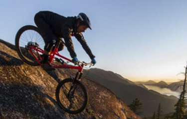 person riding a banshee bike downhill