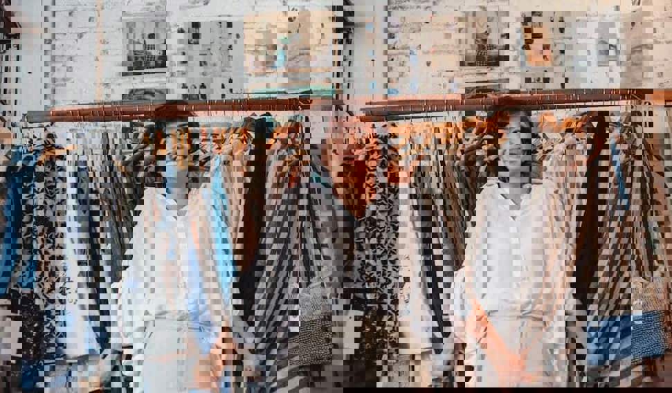 Woman stood in front of clothing rack