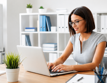 woman with grey shirt looking at laptop